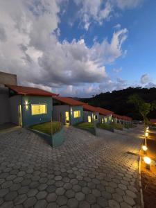 a row of houses in a parking lot at night at Pousada real chalés in Belo Vale