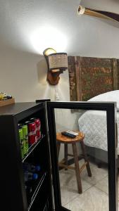 a room with a bed and a small table and a refrigerator at Refúgio Aroma do Campo in Bagé