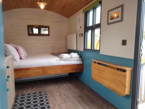 a small bedroom with a bed and a window at Dingle Way Glamping Annascaul in Anascaul