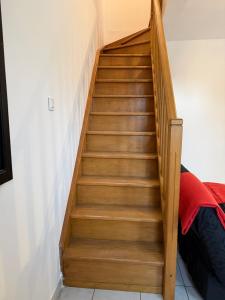 a wooden staircase in a room with a bed at Maisonnette du Prieuré in Saint-Gilles