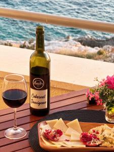 a bottle of wine and a plate of cheese and a glass at Apartments Kiro in Milna +42 photos