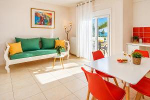 a living room with a green couch and a table at 4 Seasons villa-Sea view in Hersonissos