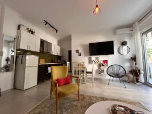 a kitchen and living room with a refrigerator and chairs at Small Garden House in Draç +4 photos