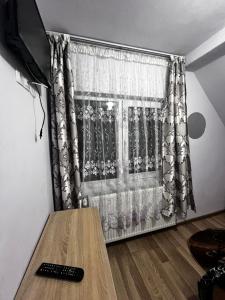 a room with a window with a television and a table at Casa Iuly in Gârda de Sus