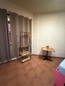 a room with a table and a shelf in the corner at Aracari Stay in Quepos