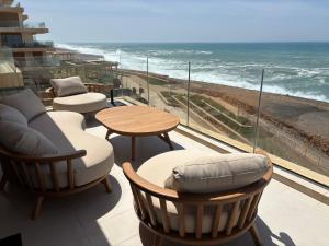 a balcony with chairs and tables and a view of the ocean at Carrousel Atlantic View in Rabat