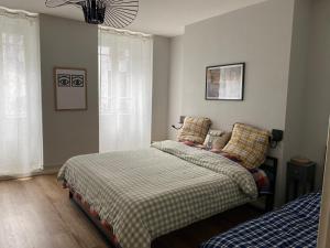 a bedroom with two twin beds and a bedskirts at MAISON GERMÈS - CENTRAL & STANDING - Appartements traversants - Lits 180 King Size - Linge de lit et de toilette inclus - Parking privé - Espace Télétravail in Luchon +102 photos