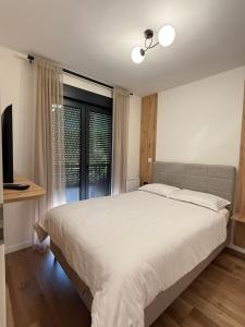 a bedroom with a large bed and a window at CENTRAL SQUARE Tuzla in Tuzla
