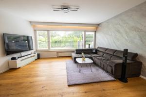 a living room with a couch and a table at Lakeside Diamond Apartment - Krumpendorf in Krumpendorf am Wörthersee