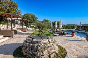 a garden with a tree in a stone planter next to a pool at Marcora Historic Mansion in Strongylí