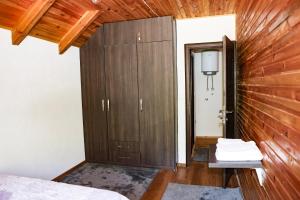 a bedroom with a wooden wall and a closet at Modra Rijeka Resort in Glavatičevo
