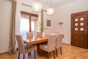 a dining room with a wooden table and chairs at Sonias Point of View in Myrties