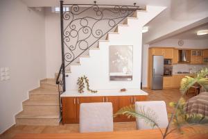 a living room with a staircase with chairs and a kitchen at Sonias Point of View in Myrties
