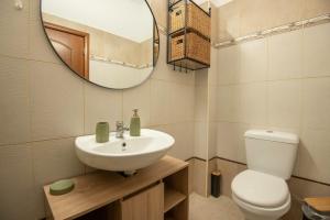 a bathroom with a sink and a toilet and a mirror at Sonias Point of View in Myrties +15 photos