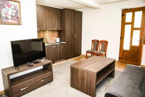 a living room with a flat screen tv and a table at Modra Rijeka Resort in Glavatičevo +18 photos