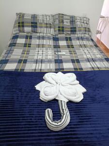 a bed with a white flower on top of it at Apartamento Indaiatuba in Indaiatuba