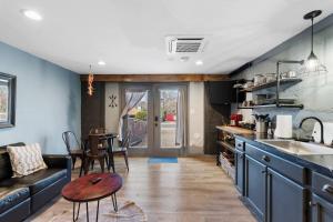 a kitchen with blue cabinets and a table and a couch at Modern Pet-Friendly Cottage - Graystone Retreat in Prescott