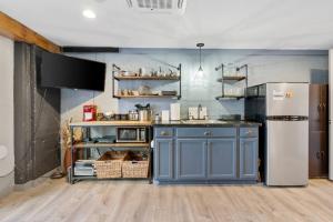 a kitchen with blue cabinets and a refrigerator at Modern Pet-Friendly Cottage - Graystone Retreat in Prescott