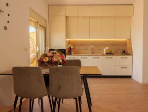 a kitchen with a table with chairs and flowers on it at Xhejn's Veranda 7 in Durrës