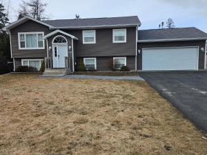 a brown house with a garage at Modern Comfort Haven Near Reversing Falls Bridge Saint John NB in Saint John