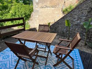 a wooden table and two chairs on a patio at Le Grain d Or in Blois