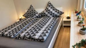 a bed with black and white pillows on it at Buddelhuus in Norddeich