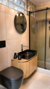 a bathroom with a black toilet and a sink at Buddelhuus in Norddeich +30 photos