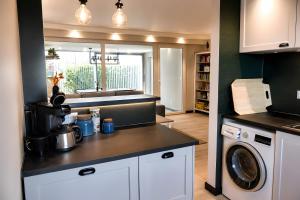 a kitchen with a washing machine and a washer at Buddelhuus in Norddeich