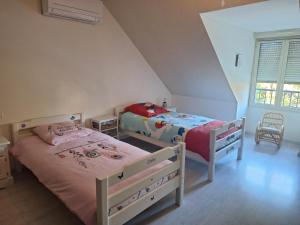 a bedroom with two beds and a window at Chambres à 10 min du circuit des 24h en campagne in Guécélard +7 photos