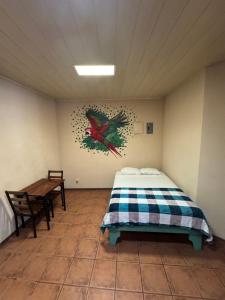 a bedroom with a bed and a table in it at Aracari Stay in Quepos
