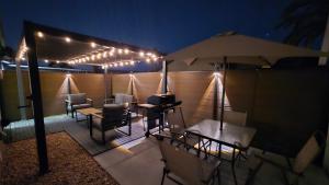 a patio with tables and chairs and an umbrella at night at Cozy Private Retreat in Phoenix