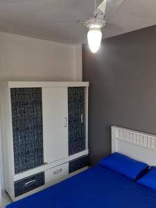 a bedroom with a blue bed and a window at Apartamento 204 com vista da piscina e mar in Piúma +61 photos