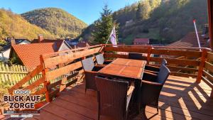 a wooden deck with a table and chairs on it at Arode Lodge Blick auf Zorge - Mountain Lodge with Panoramic Views in Zorge