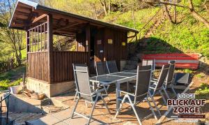 a table and chairs in front of a wooden building at Arode Lodge Blick auf Zorge - Mountain Lodge with Panoramic Views in Zorge +46 photos