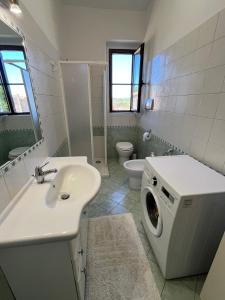 a bathroom with a sink and a washing machine at Il Quinto senso di Lù in Capalbio