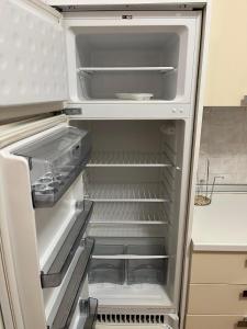 an empty refrigerator with its door open in a kitchen at Il Quinto senso di Lù in Capalbio +18 photos