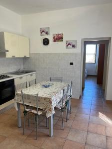 a kitchen with a table and chairs in a kitchen at Il Quinto senso di Lù in Capalbio