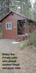 a red shed with a door and stairs to it at Sometimes Creek Cabins in Seward
