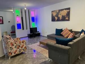 a living room with a couch and chairs and a tv at Villa Belle-Vue in Tabarka