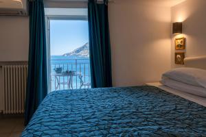 a bedroom with a bed and a view of the ocean at Villa Costanza Amalfi Coast in Maiori