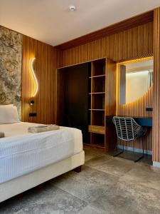 a bedroom with a bed and a chair at IONIAN SUITES by Bruskos in Agios Georgios +62 photos