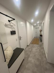 a hallway with white walls and a room with a couch at MelSun Apartment in Melsungen