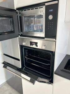 two microwaves are stacked on top of each other in a kitchen at MelSun Apartment in Melsungen