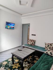 a room with a couch and a table and a tv at tamraght samba 2 in Tamraght Ou Fella