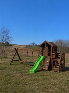 a playground with a slide and a play structure at Domki nad Szóstakiem in Orzechowo
