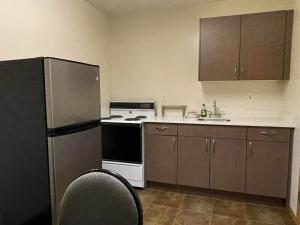 a kitchen with a refrigerator and a stove and a sink at Chalet Continental Motel in Valemount