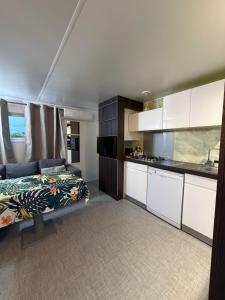 a bedroom with a bed and a kitchen at Mobil Home La Barrosa in Chiclana de la Frontera