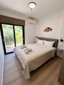 a bedroom with a large bed with towels on it at Solmare Apartments in Nikiana