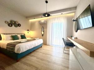 a bedroom with a bed and a large window at IONIAN SUITES by Bruskos in Agios Georgios