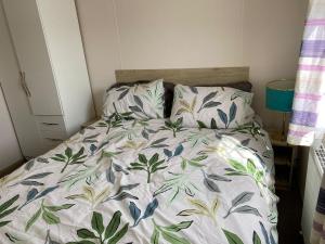 a bed with a floral comforter in a bedroom at Faville in Selsey